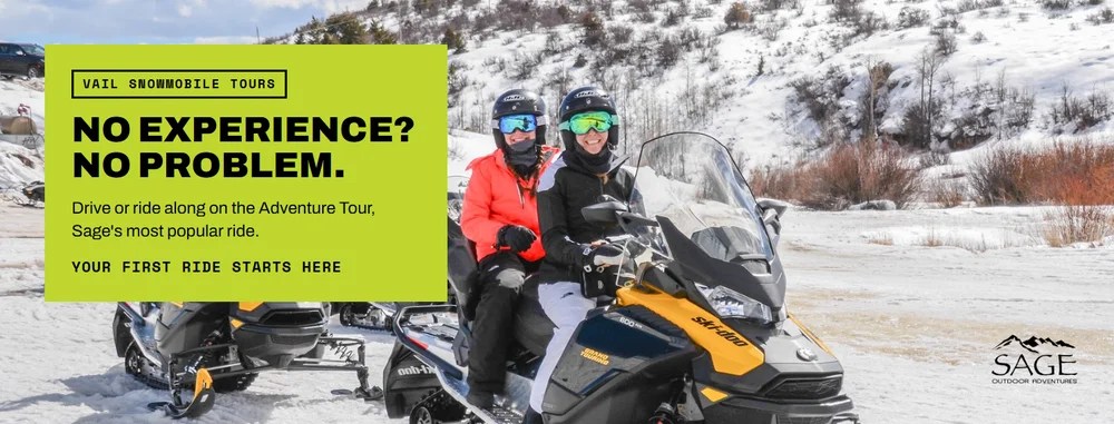 Two riders smiling on a Vail snowmobile tour