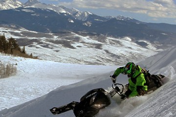 a man riding a snowboard down a snow covered mountain