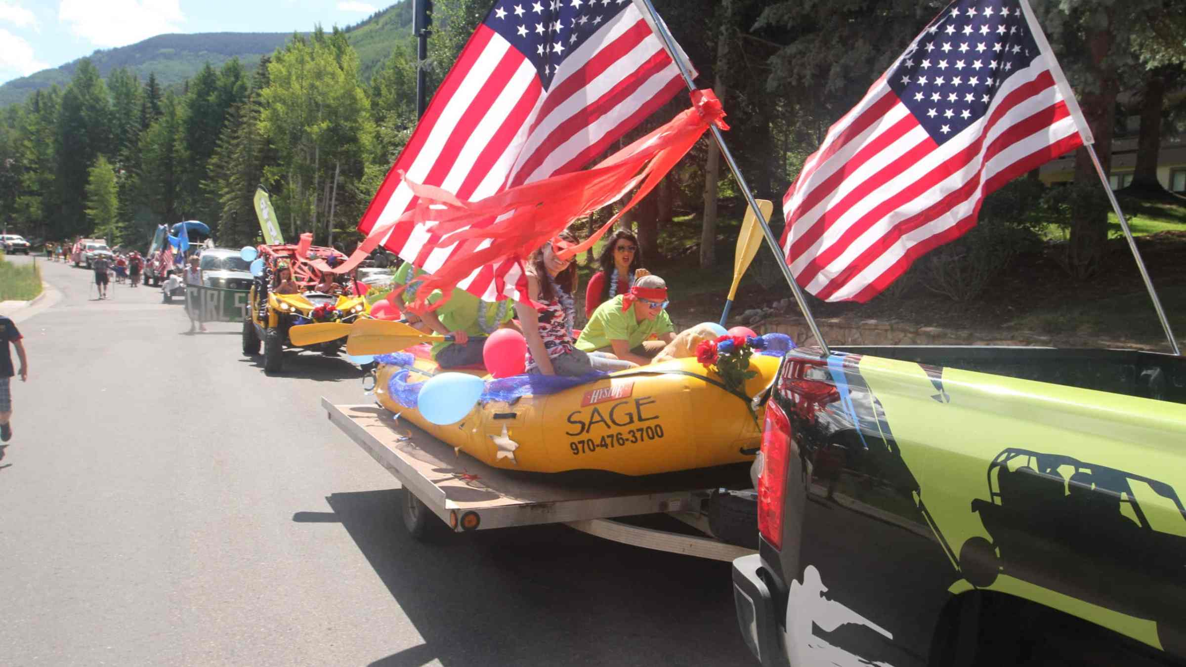 people riding in a raft on a trailer in a parade