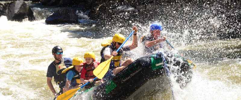 Snow Update: What it means for Snowmobiling and Summer Rafting a man riding a wave on a surfboard in the water