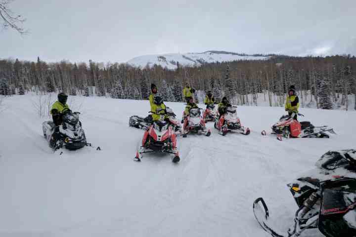 a group of people on snowmobiles