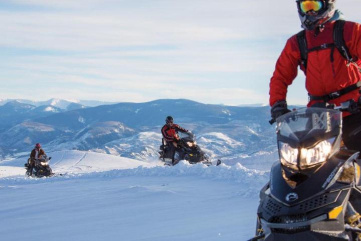 a man riding a snowboard down a snow covered slope
