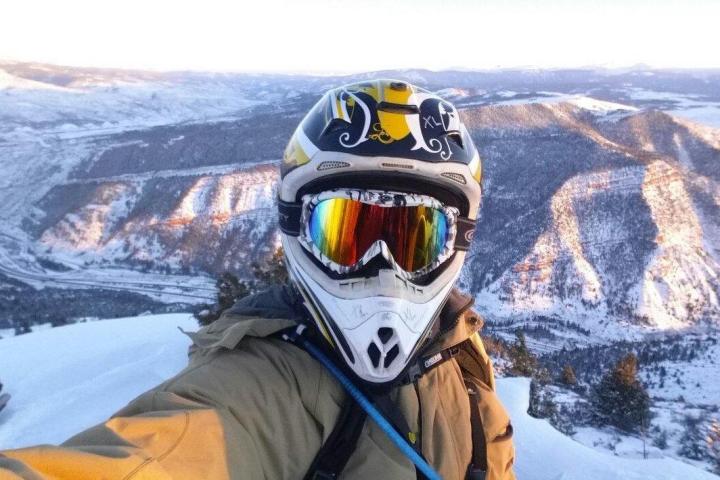 a man riding a snowboard down a snow covered mountain