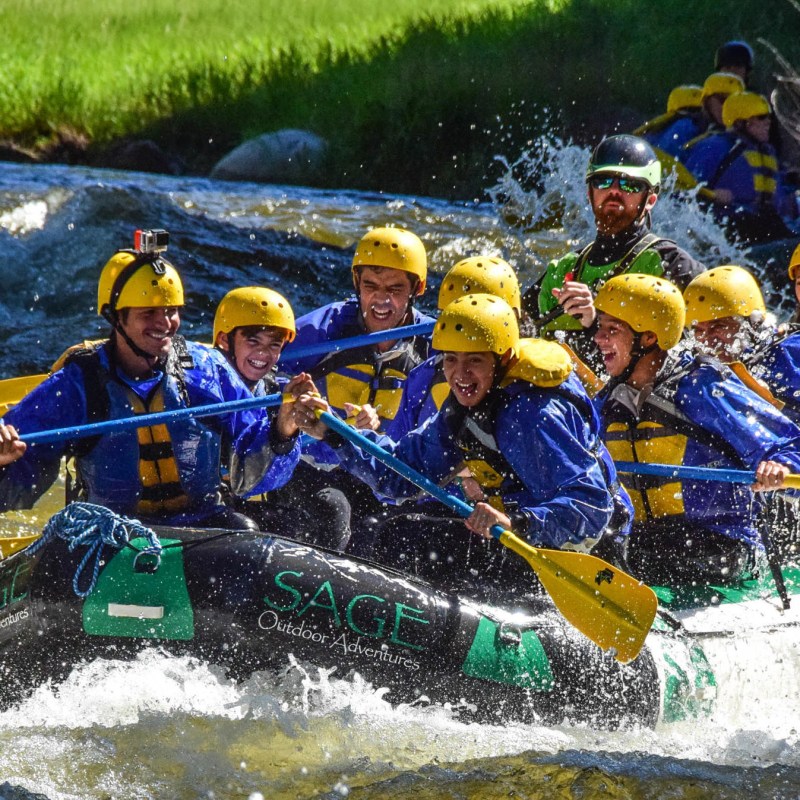 a group of men riding on the back of a raft