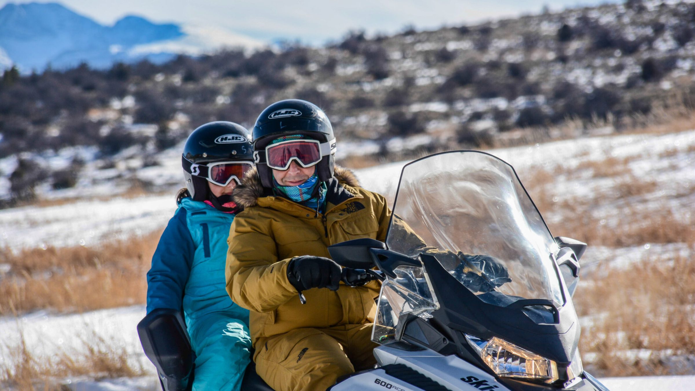 two people sitting on a snowmobile