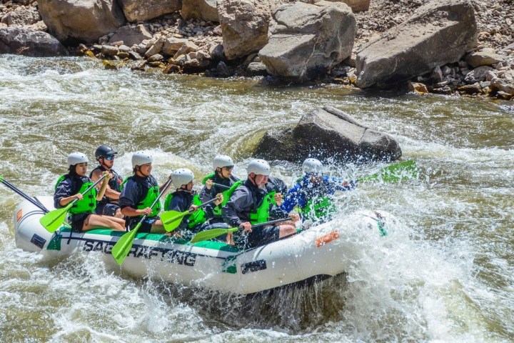 a group of people riding on a raft in the water