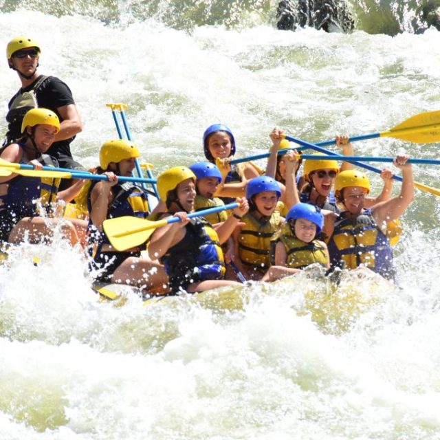 a group of people riding on a raft in a body of water
