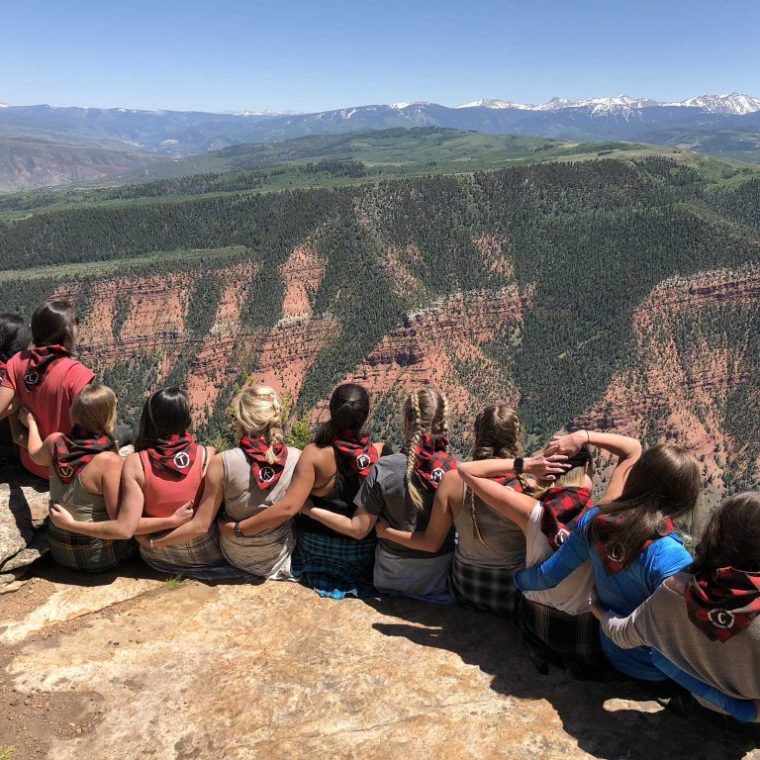a group of people sitting on top of a mountain