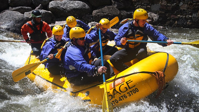 raft_booknow a group of people riding on a raft