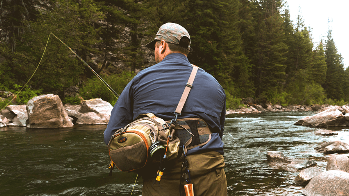 a man standing next to a river