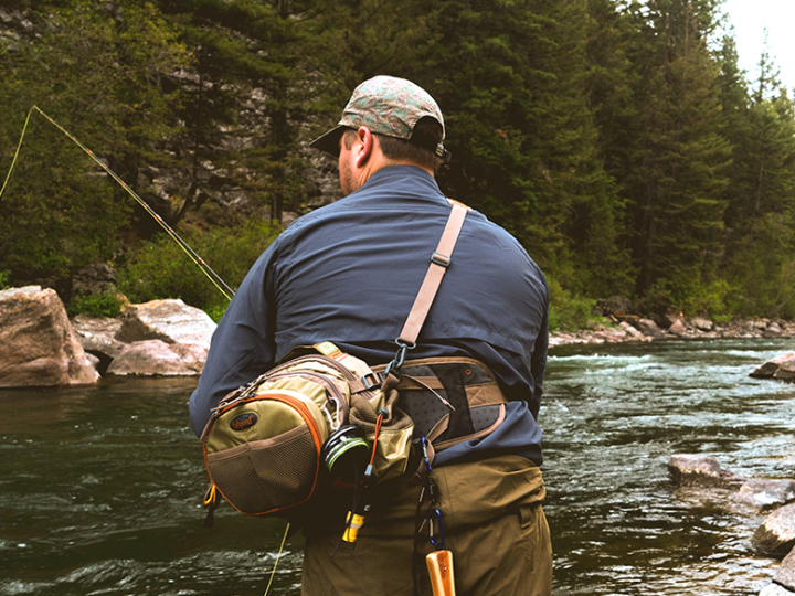 a man standing next to a river