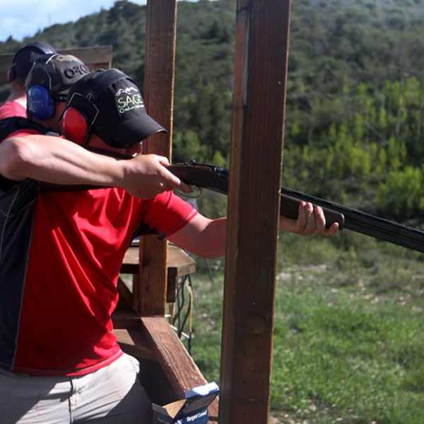 a man holding a bat on top of a wooden fence