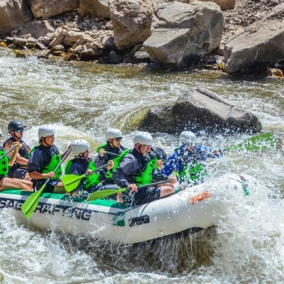 a group of people riding on a raft in the water