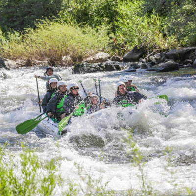a man riding a wave on a raft in a body of water