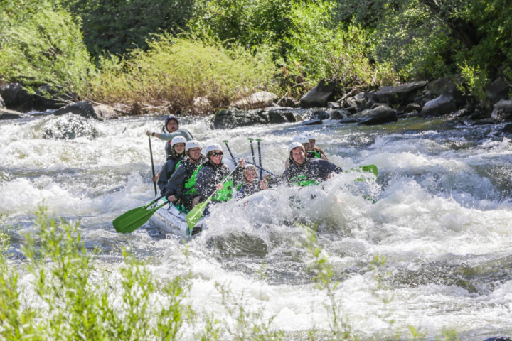 a man riding a wave on a raft in a body of water