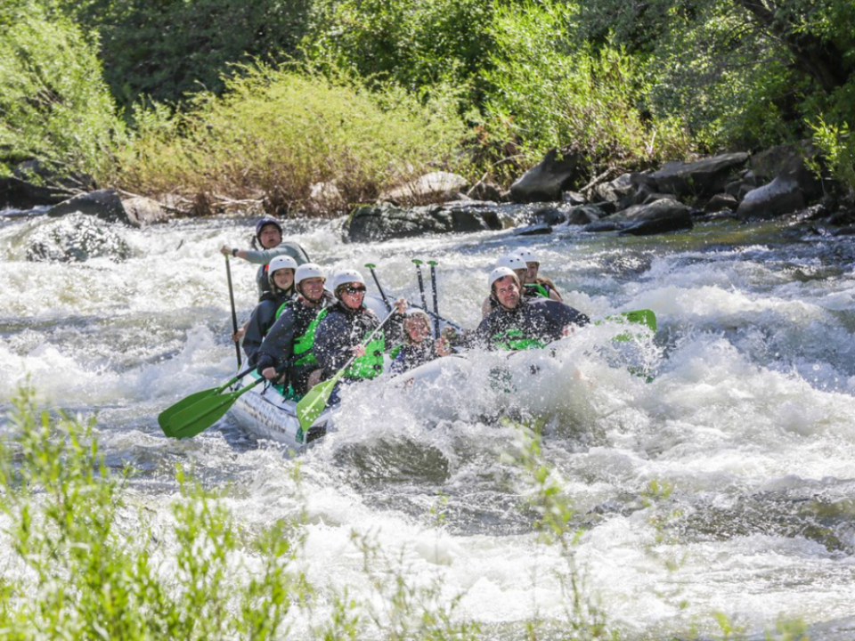 a man riding a wave on a raft in a body of water