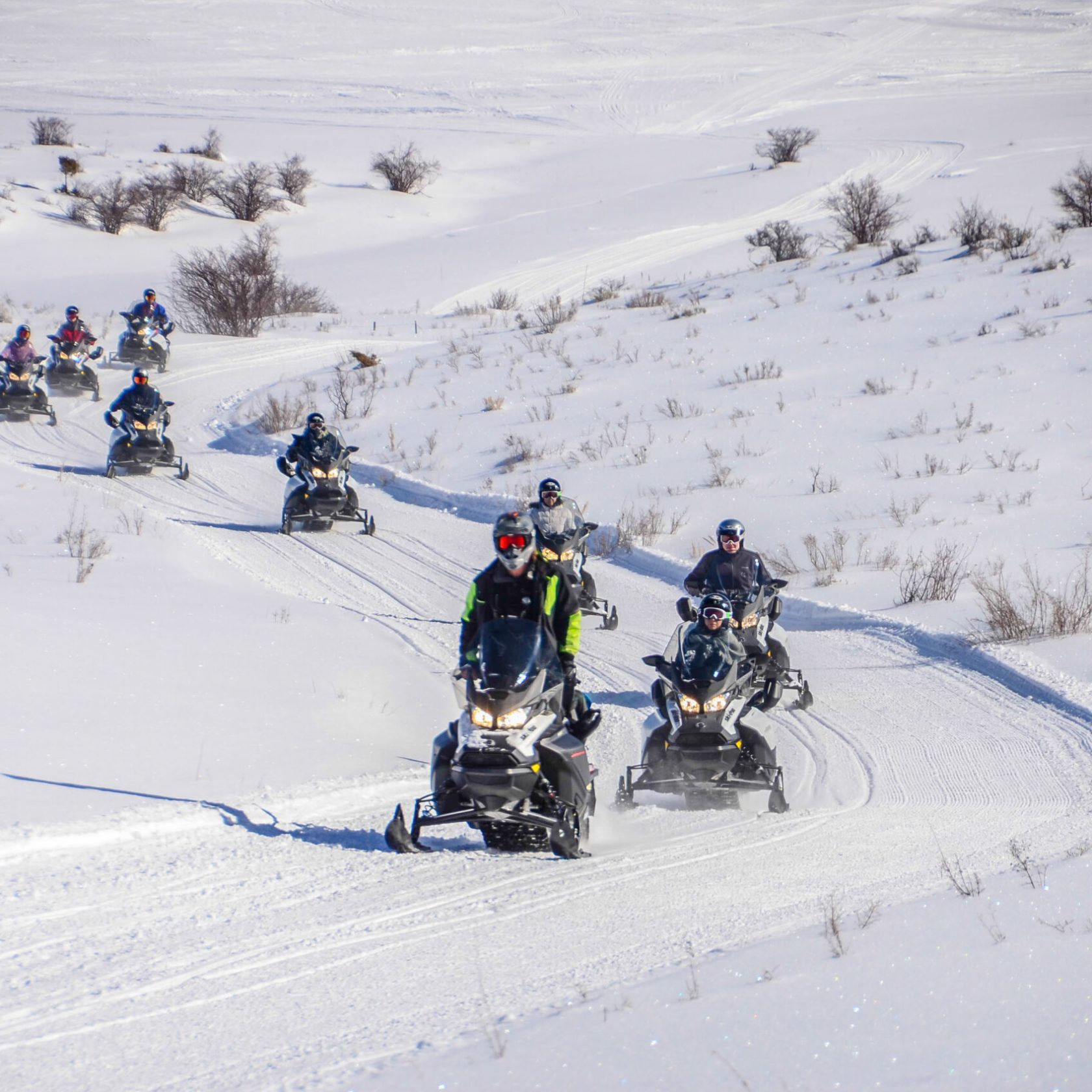 a group of people riding skis down a snow covered slope