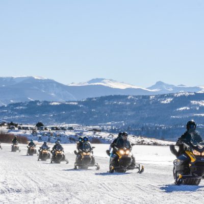 a group of people sitting on top of a snow covered mountain