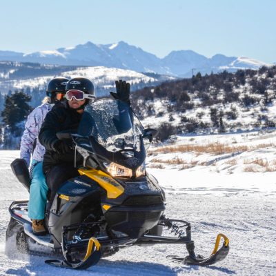 a man riding a snowboard down a snow covered mountain