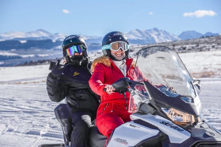 a person sitting on top of a snow covered slope