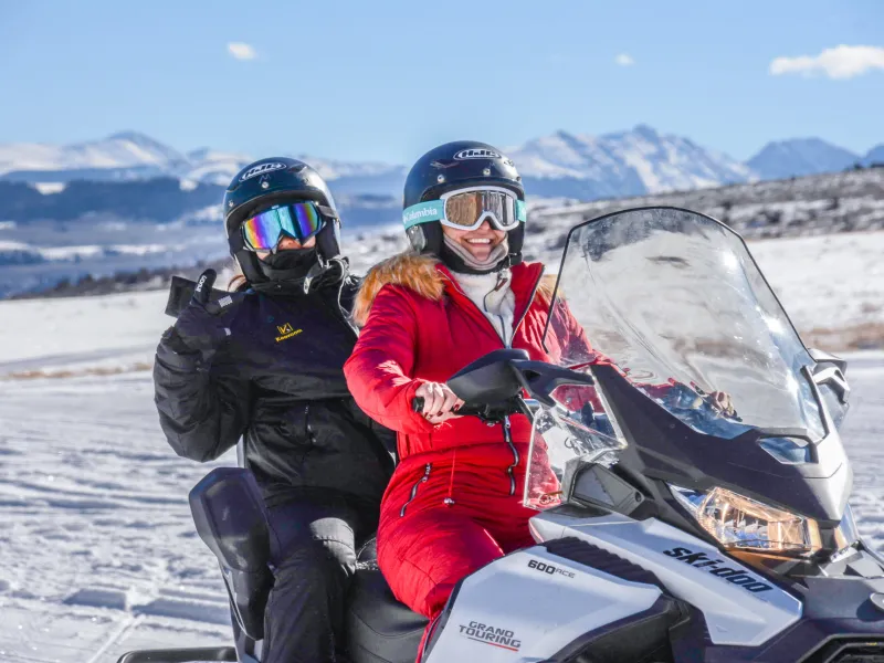 a person sitting on top of a snow covered slope