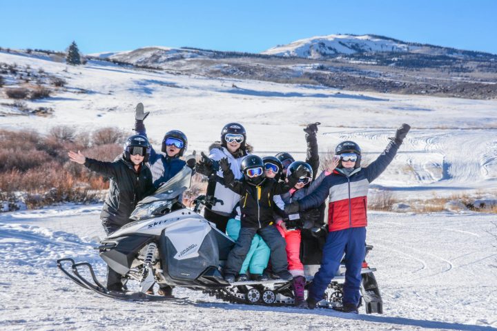 a group of people riding skis on a snowy mountain