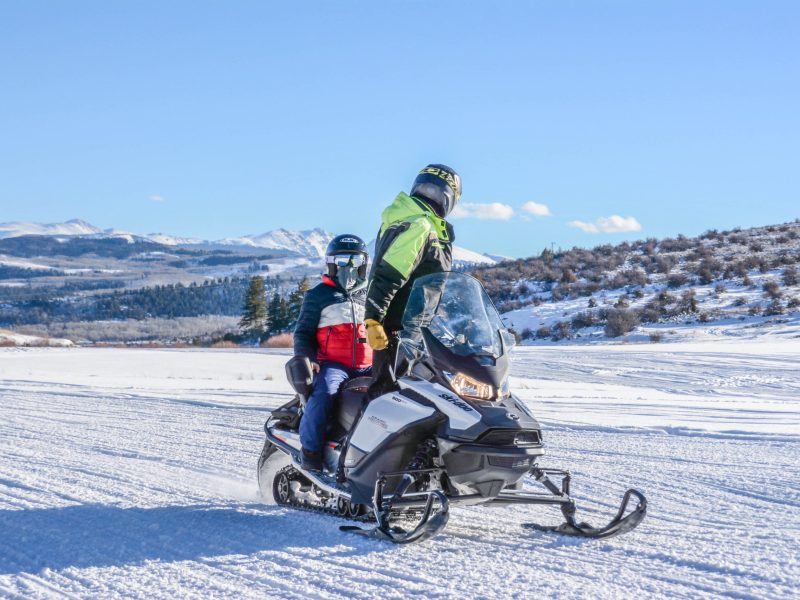 a man riding a snowboard down a snow covered slope