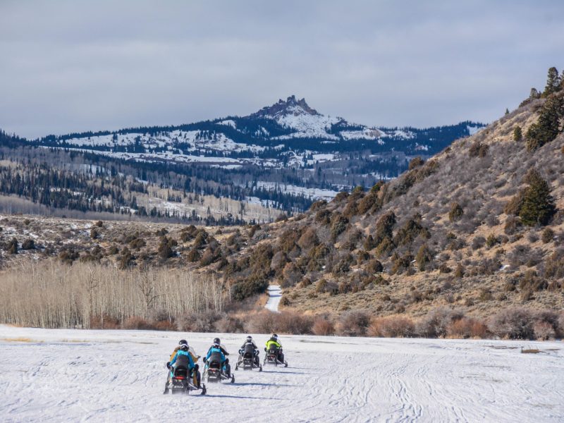 a group of people riding on top of a snow covered mountain