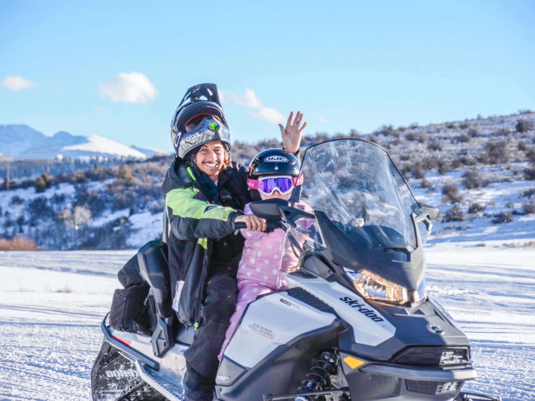 a person riding a motorcycle down a snow covered mountain