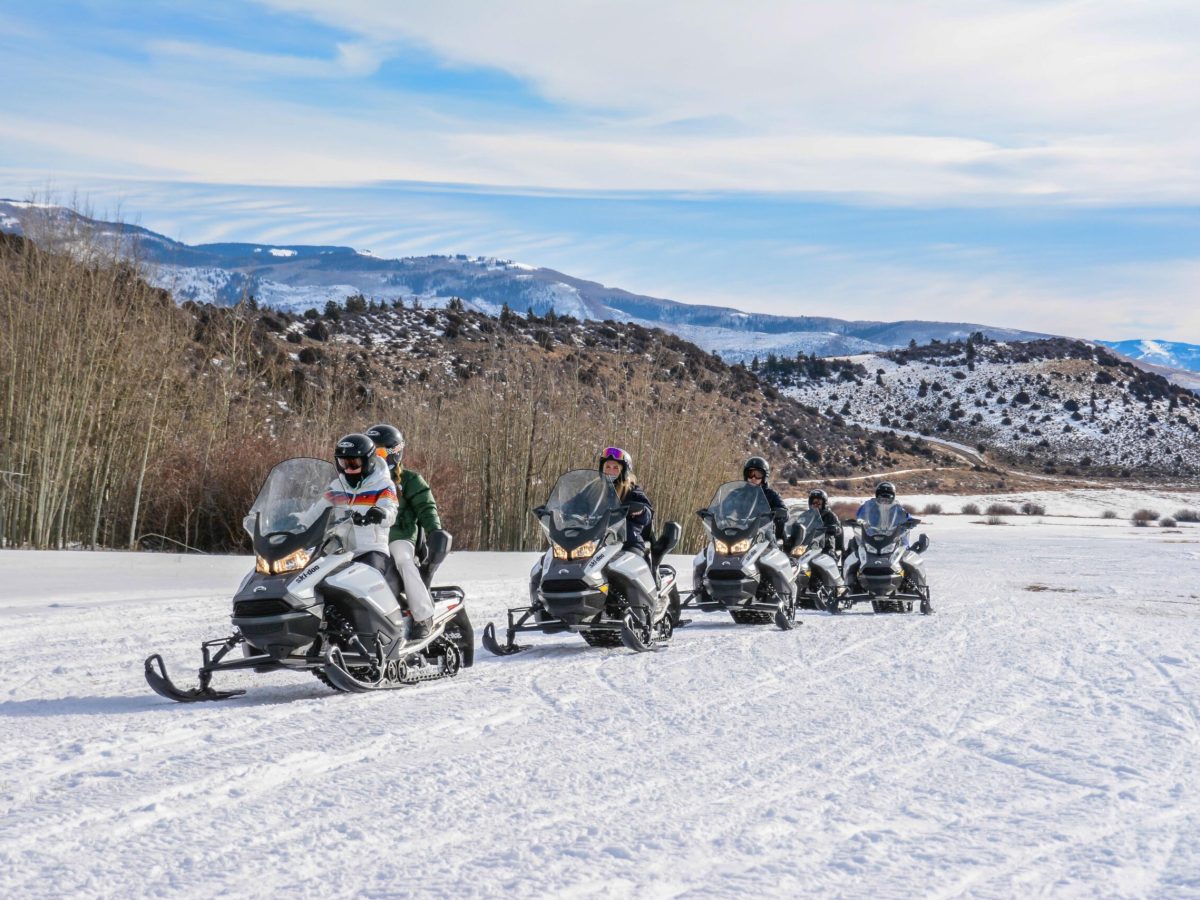 a group of people sitting in the snow