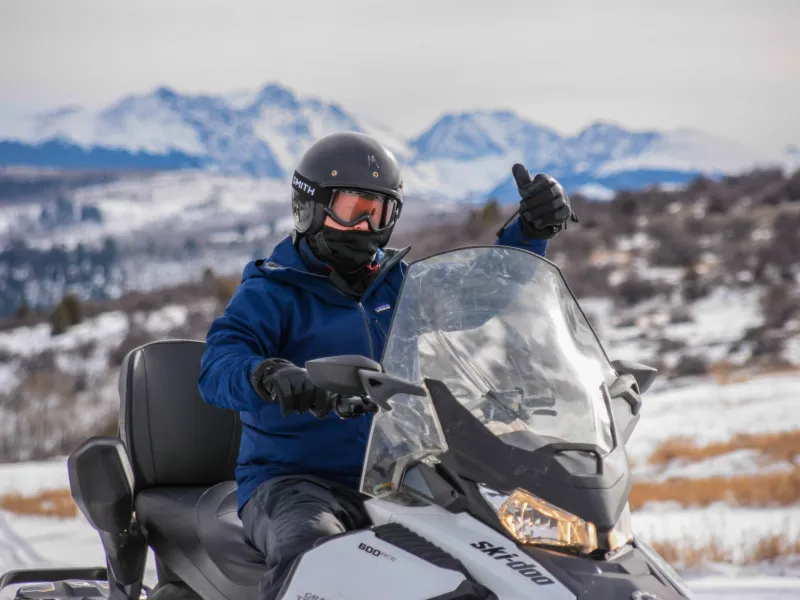 a man sitting on top of a snow covered slope