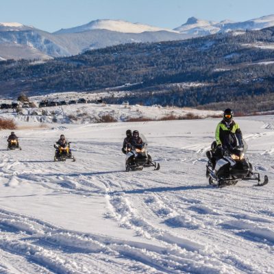 a group of people riding skis on a snowy mountain