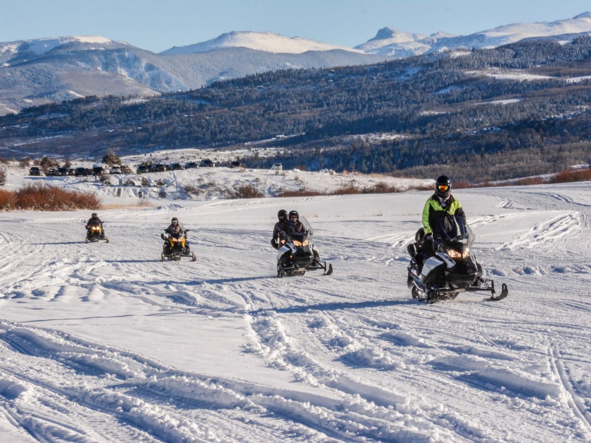 a group of people riding skis on a snowy mountain