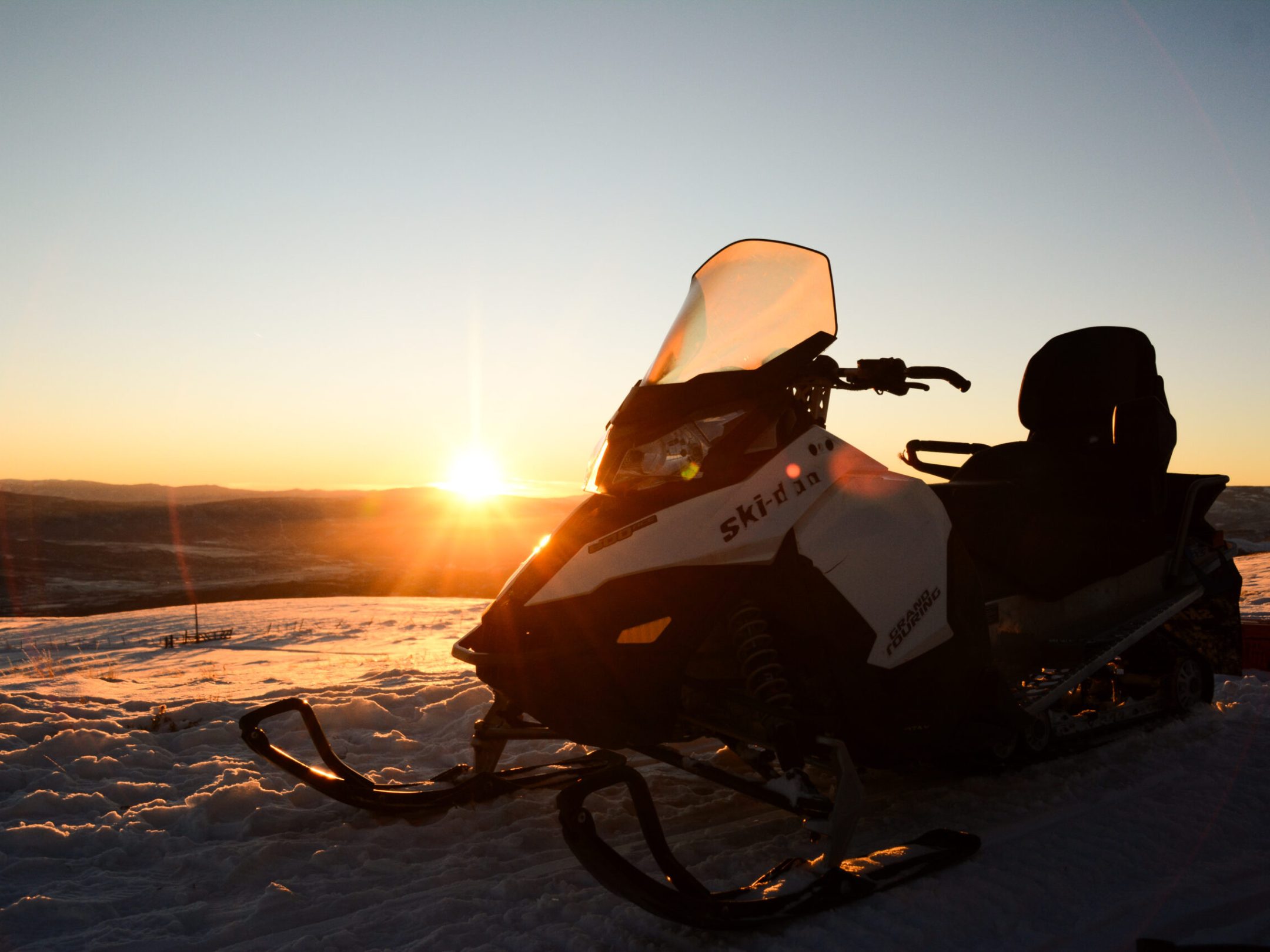 a person sitting on a motorcycle in front of a sunset