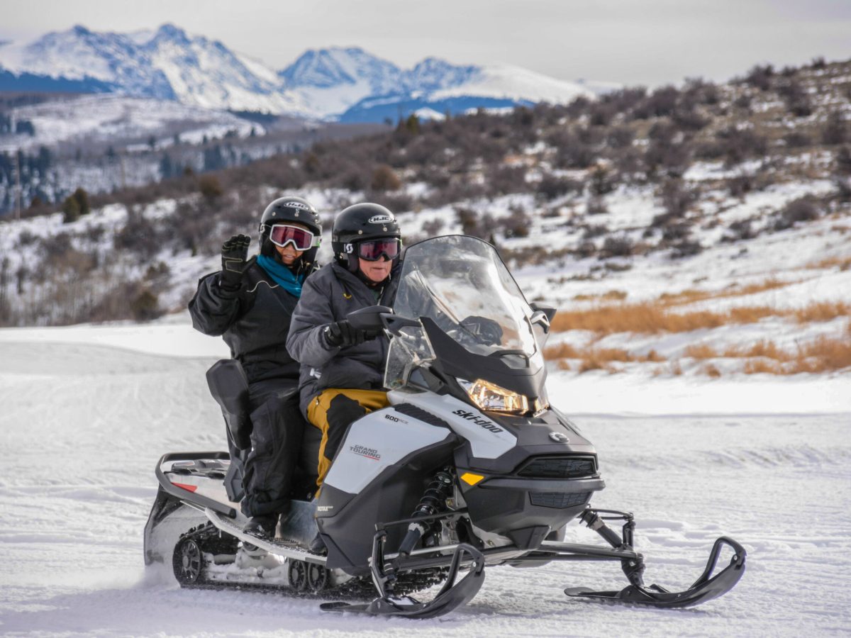 a man riding a motorcycle down a snow covered mountain