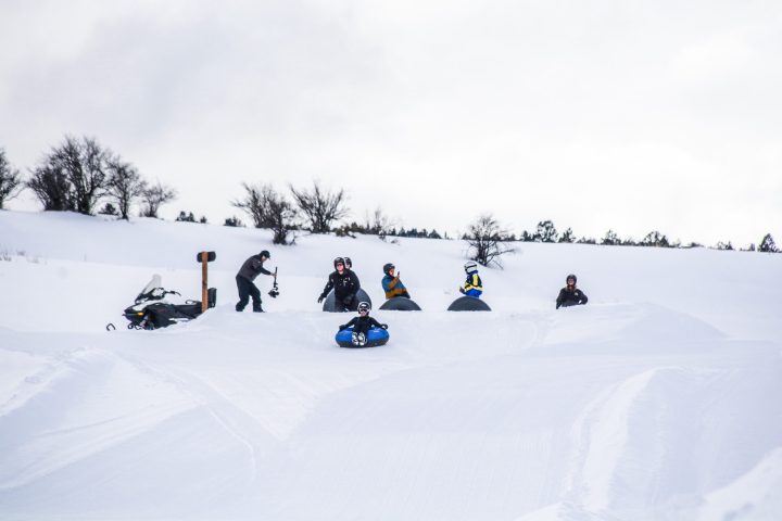 a group of people riding skis down a snow covered slope