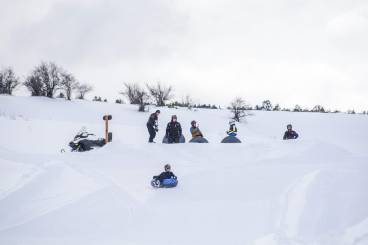 a group of people riding on top of a snow covered slope