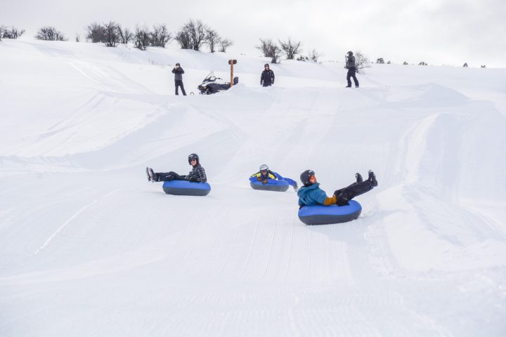 a group of people riding skis down a snow covered slope