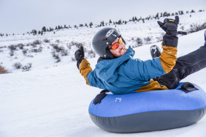 a man riding a snowboard down a snow covered slope