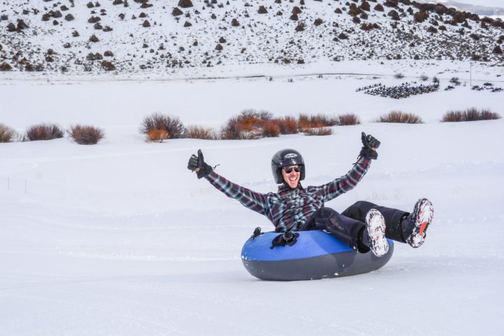 a man riding a snowboard down a snow covered slope