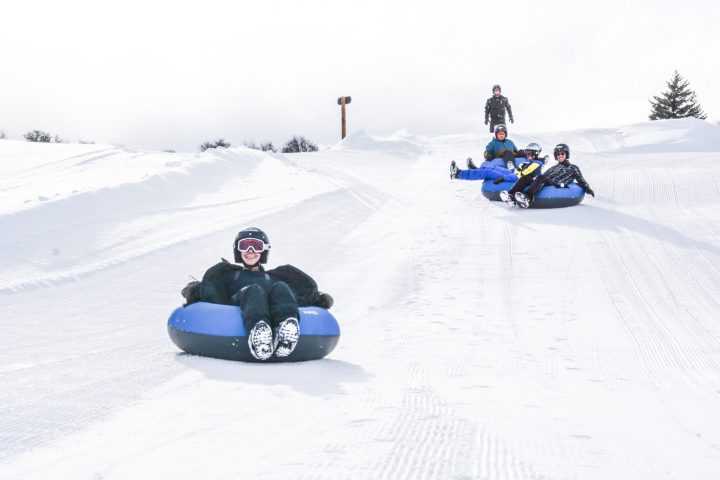 a man riding a snowboard down a snow covered slope