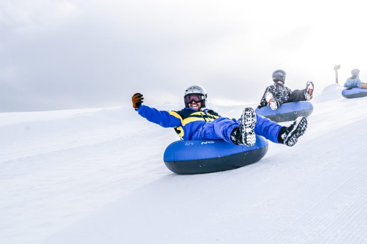 a man riding a snowboard down a snow covered slope