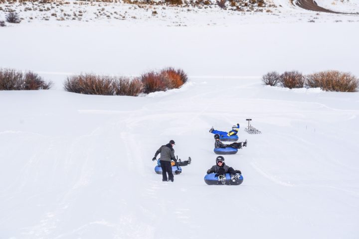 a group of people riding skis down a snow covered slope