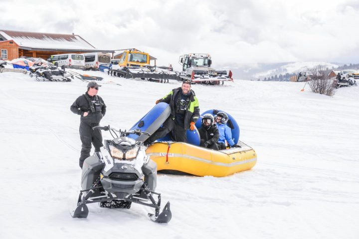 a man riding a snowboard down a snow covered slope