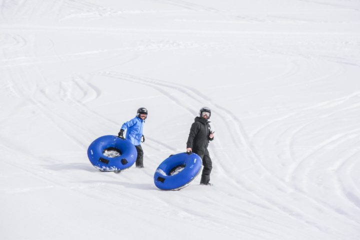 a person riding a snowboard down a snow covered slope