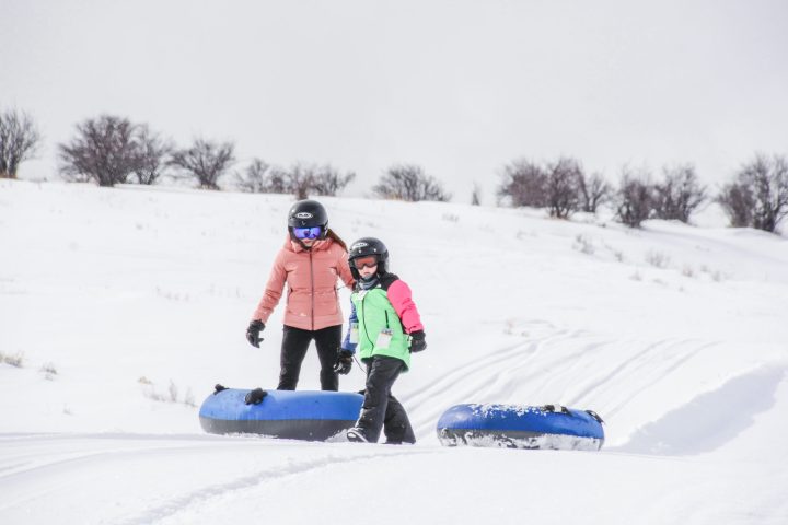 a person riding a snowboard down a snow covered slope