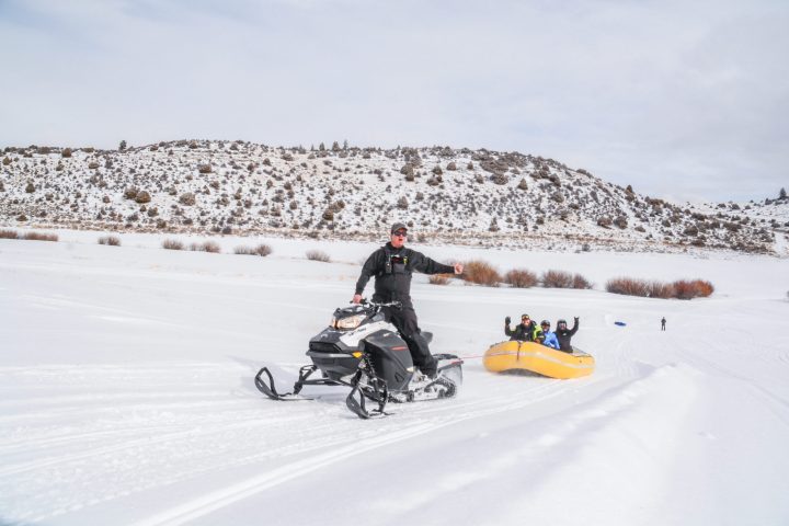 a man riding skis down a snow covered ski snowmobile