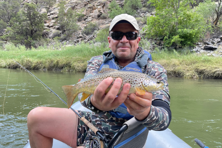 a person holding a fish on a boat in a body of water