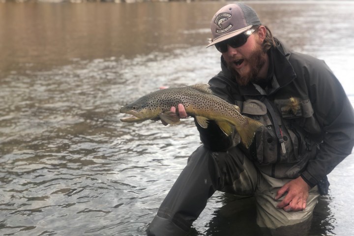 a man holding a fish in the water